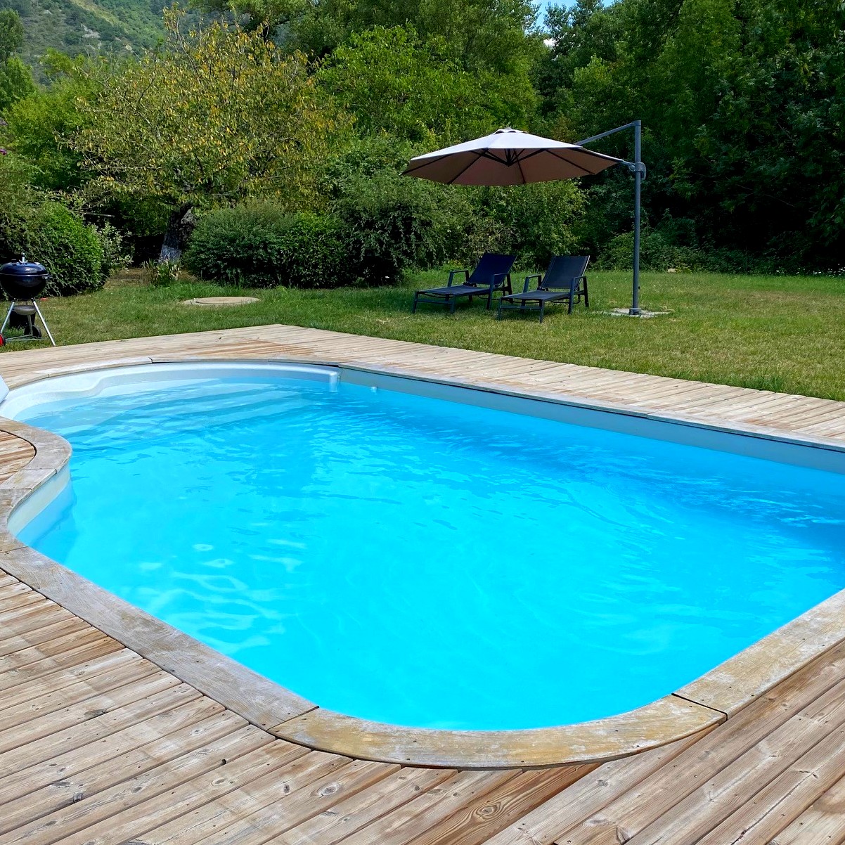 Swimming pool with sunbathing area and parasol Swimming pool with sunbathing area and parasol